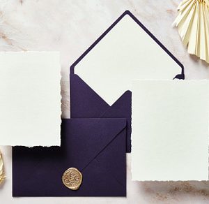 Flat lay purple envelopes and wedding cards mockups with dried flowers on marbl
