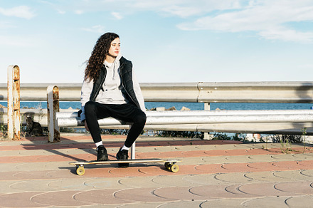 Teenage girl sitting on a bench with stock photo containing female and woman